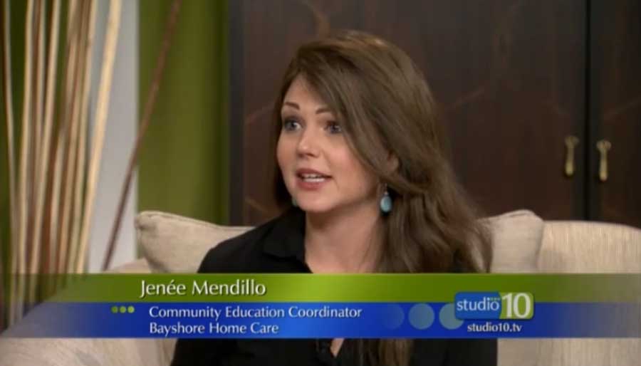 A woman sitting on a white couch while giving an interview