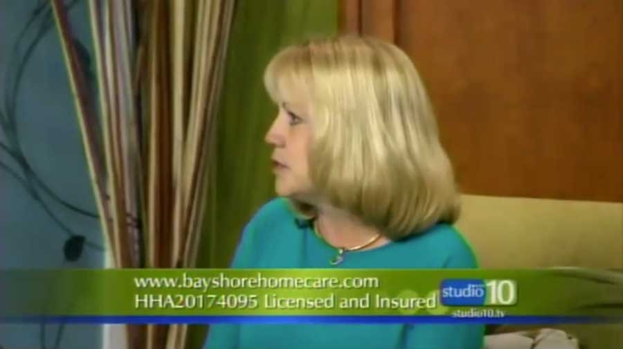 A woman sitting on a green couch and being interviewed